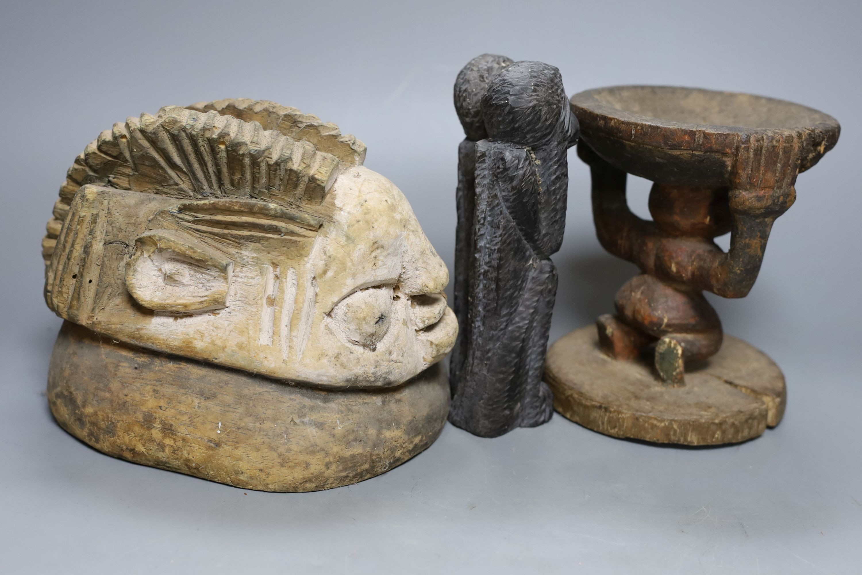 A tribal figural stool (15.5cm), similar mask head-dress and two smaller hardwood carvings